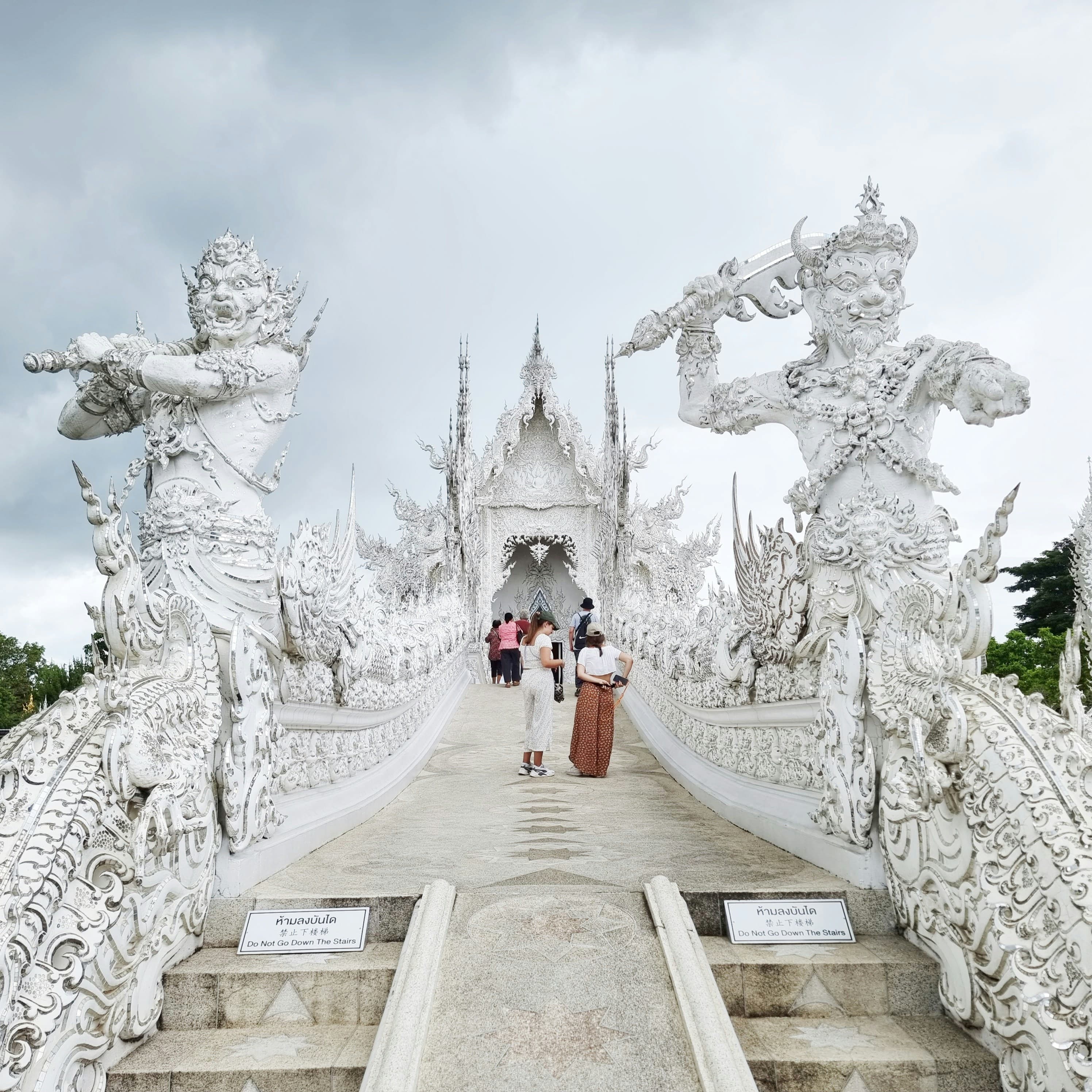 Visitors crossing the bridge at Wat Rong Khun