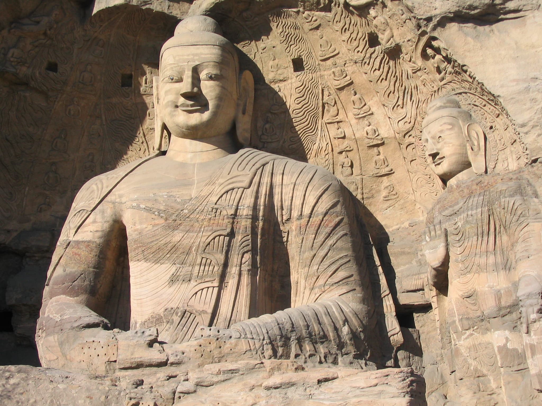 Two Buddhist statues. The cave front has collapsed, leaving them visible from outside. Yungang Grottoes, near Datong, Shanxi province, China.