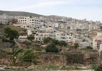 This is a residential neighborhood in Nablus. In the foreground, are ruins that seem to date from classical antiquity. Note the ground around the ruins is lower then the level of the modern street.