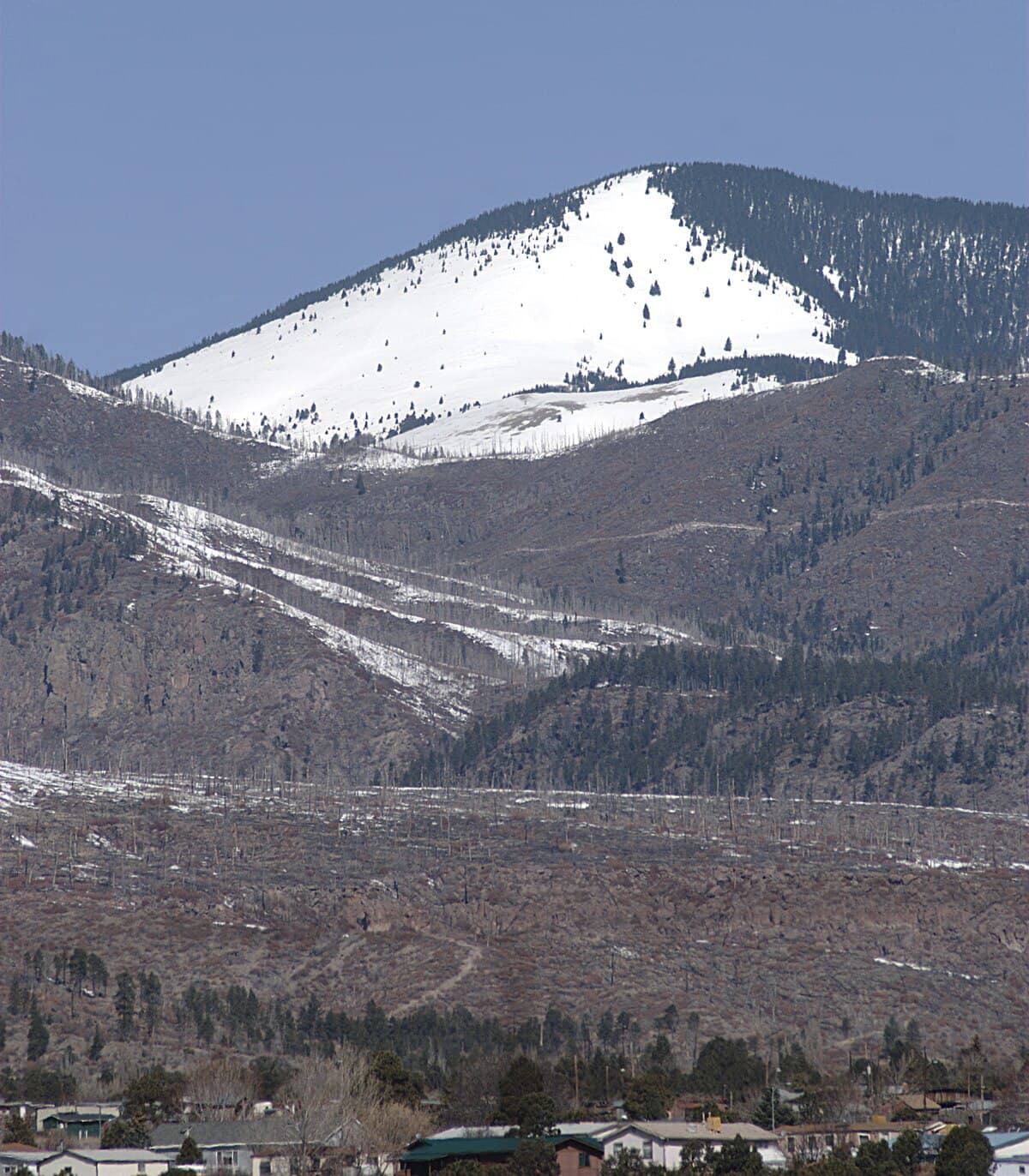 Chicoma, the highest peak in the Jemez Mountains, New Mexico, in snow.  Some houses in Los Alamos, New Mexico, are visible.  From East Road (New Mexico 502), Los Alamos, New Mexico.
