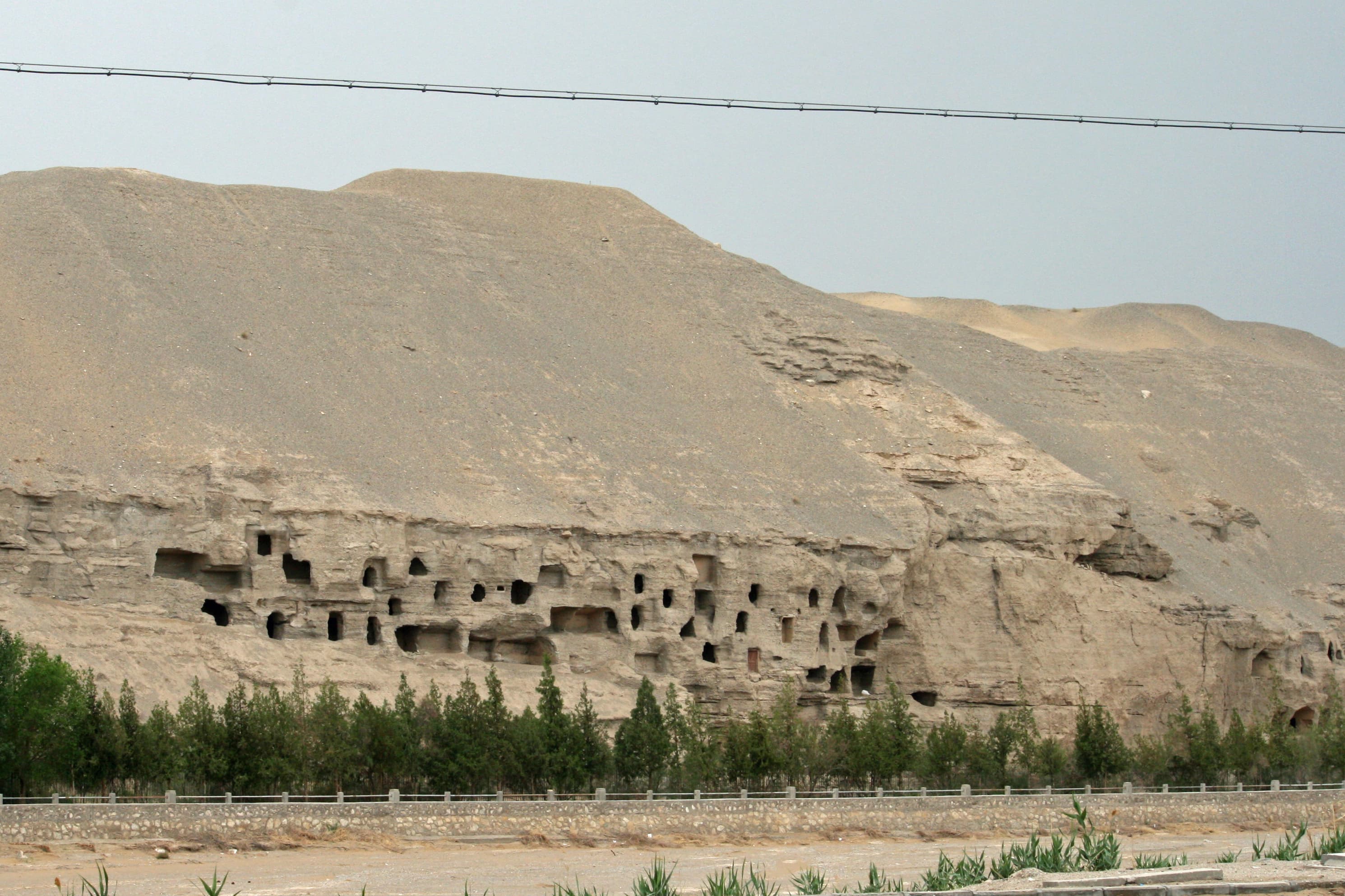 Cave openings across the rock face at Mogao